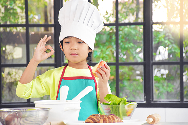 Boy cooking and wearing a chef's hat